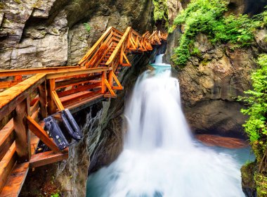 Wooden hike trail path inside a gorge with bue mountain river, Sigmund Thun Klamm, Kaprun, Austria clipart