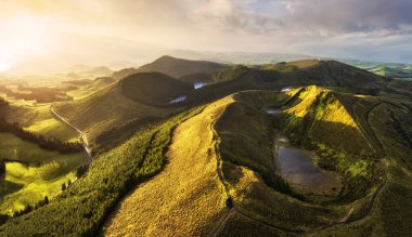Manzara üzerinde gün batımı Volkan 'dan yağmur ormanlarına göl ve odunlu insansız hava aracı resmi, Azores.