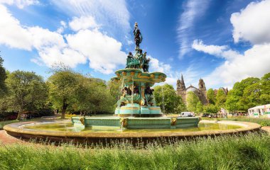 Mavi gökyüzünde Edinburgh Şatosu, güneş ve bulutlar ve Ross Fountain, İskoçya - İngiltere