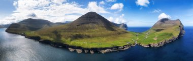 Hava manzarası fotoğrafçılığı. Vidareidi köyünün insansız hava aracından inanılmaz bir yaz manzarası. Güzel bir yaz manzarası. Faroe Adaları, Danimarka, Avrupa Vidoy Adası 'nın güneşli açık hava manzarası.