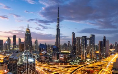 Geceleri Dubai 'nin modern mimarisinin aydınlık gökdelenleriyle muhteşem çatı manzarası, BAE