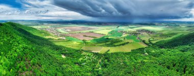 Bir köyün üzerinde fırtına yağmurlu bulutlar ve yeşil dağ ve arazi manzarası - Slovakya 'nın panoraması