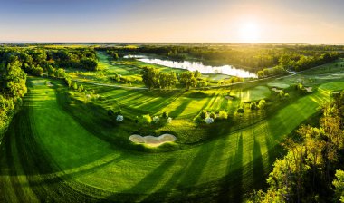 Golf sahasındaki yeşil çimlerin ve ağaçların havadan görünüşü