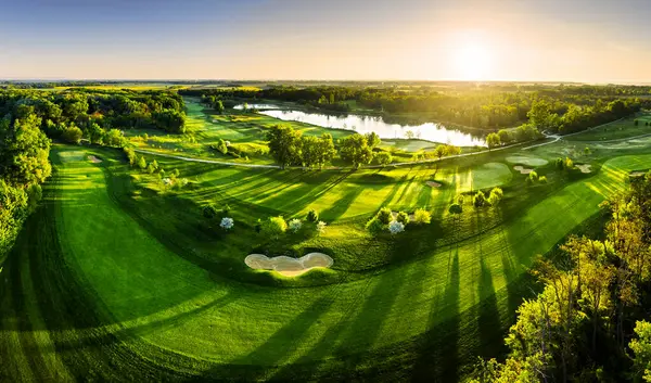 Golf sahasındaki yeşil çimlerin ve ağaçların havadan görünüşü