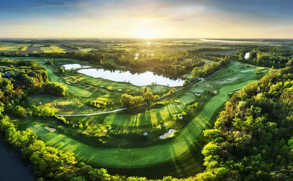 Gün batımında golf sahasında güzel bir gökyüzü ve kum tuzağı. İHA 'nın sığınağıyla golf sahasının manzaralı manzarası