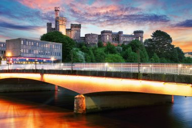 İskoçya - İngiltere 'nin dramatik günbatımında Ness Nehri' nde kale yansıması ile Inverness silueti yükseldi