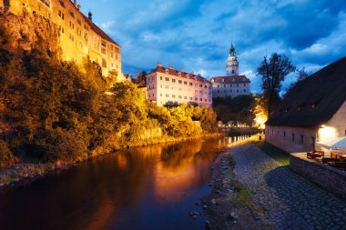 Cesky Krumlov 'daki Vltava kalesi ve nehir manzarası gün batımından sonra, Çek Cumhuriyeti geceleri