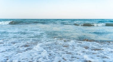 Akşam vakti deniz kıyısında rahatlatıcı manzarayla