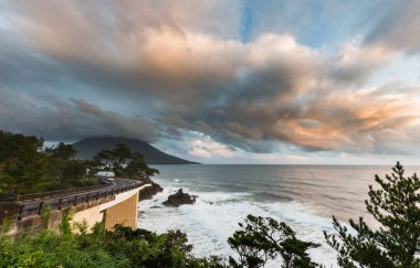 Mt. Dağın yanındaki sahil yolu. Güzel günbatımında Kaimon volkanı, Kagoshima, Kyushu, Japonya