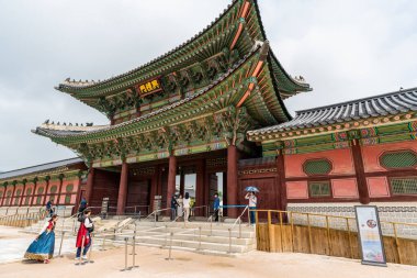 Seul, Güney Kore - 29 Haziran 2018: Joseon hanedanlığının ana sarayı olan Gyeongbokgung Sarayı 'nı ziyaret ederken geleneksel Koreli Hanbok gibi giyinen turistler.