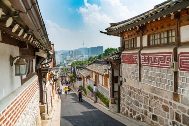 Seul, Güney Kore - 29 Haziran 2018: Güney Kore 'nin Seul kentinde Bukchon Hanok köyünde Kore tarzı tarihi bir mahallede yürürken geleneksel Koreli Hanbok gibi giyinen turistler.