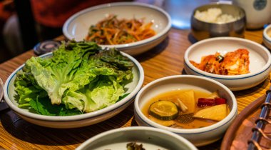 Korean barbecue sidedish with green lettuce, pickle and Kimchi. clipart