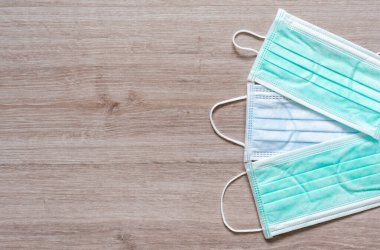 Tahta arka planda kovid 19 hastalığını önlemek için cerrahi yüz maskeleri.