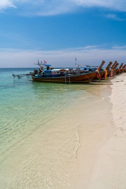 Tayland 'ın güneyinde, Sai Khao Sahili, Ra Wi Adası' nda kristal berrak suda geleneksel uzun kuyruk tekneleri..
