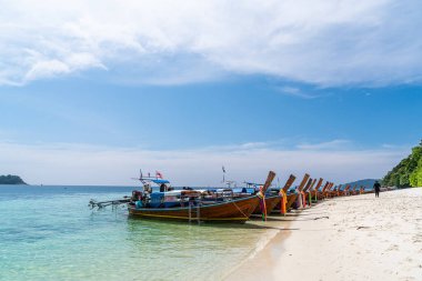 Tayland 'ın güneyinde, Sai Khao Sahili, Ra Wi Adası' nda kristal berrak suda geleneksel uzun kuyruk tekneleri..