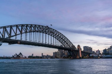 Sydney Limanı Köprüsü ile Sydney CBD şehir merkezi günbatımında ufuk çizgisi, Sydney, New South Wales, Avustralya.