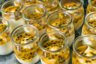 Kahvaltı için küçük kavanozlarda tutku meyveli yoğurt..