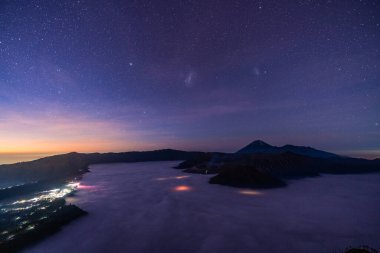 Doğu Java, Endonezya 'da geceleyin milyon yıldızlı Bromo Dağı volkanı sabah sisi ile çevrili.