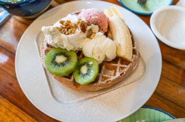 Vanilyalı waffle ve taze meyve ve muzlu çilekli dondurma..