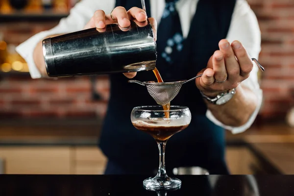 close up of barman preparing cocktail in bar