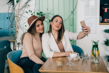 Arkadaşlar kafeteryada selfie çekiyorlar.