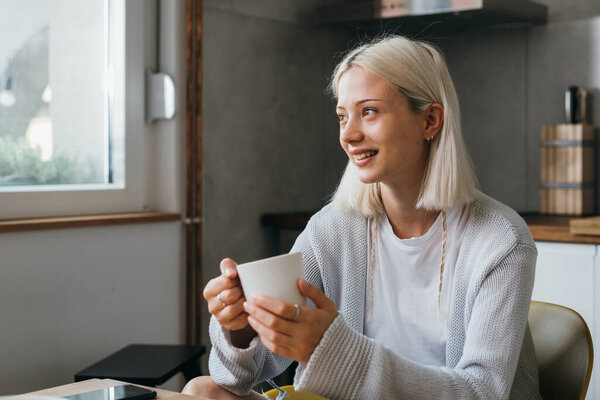Woman drinking morning coffee at home