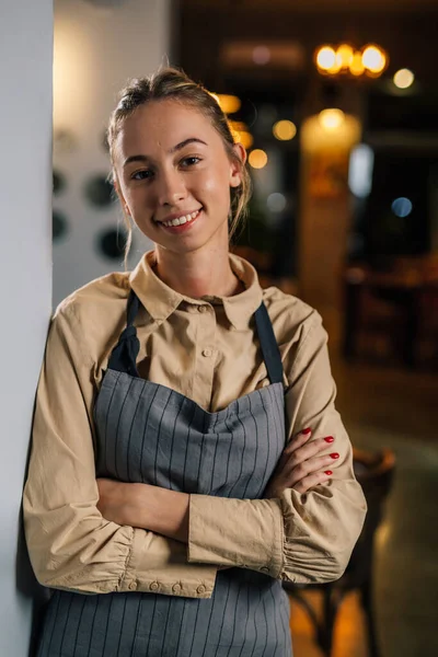A young woman works at a restaurant