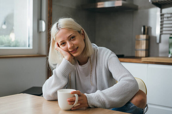 Portrait of a young European woman lokking at camera at home
