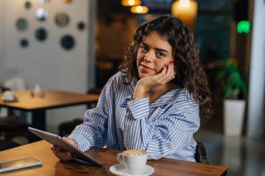 Kafe müdürü kameraya bakıyor.