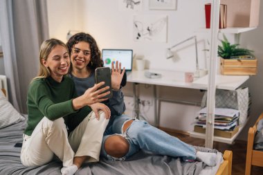 Birinci sınıftan iki öğrenci bir video çağrısına birlikte cevap veriyor.