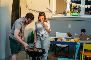 Annem babama barbeküde eşlik ediyor.