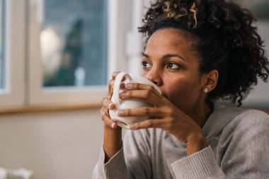 Kahve içen güzel bir kadının yakın görüntüsü.