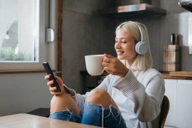 Güzel bir kadın sabah kahvesini müzikle içer.