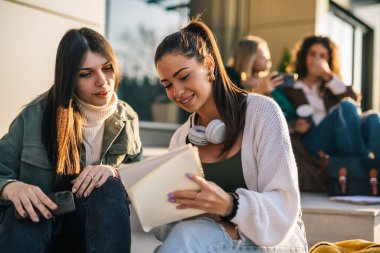 Arkadaşlar sınav için dışarıda çalışırlar.
