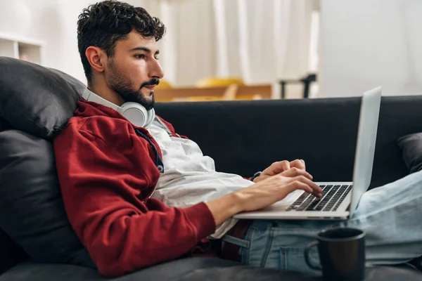 若いビジネスマンはノートパソコンで家から仕事をしてる — ストック写真