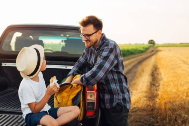 Baba ve oğul doğada yemek yiyorlar.