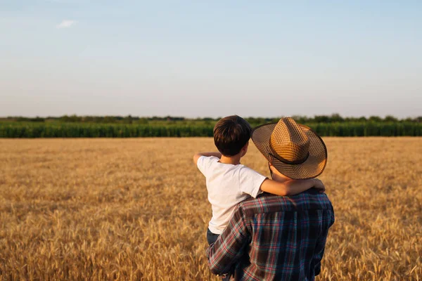 Father and son looking at their wheat field together