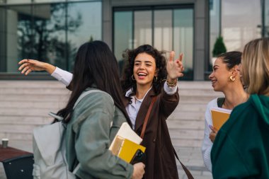 Üniversite öğrencisi sıcak bir kucaklaşmayla arkadaşını selamlıyor.