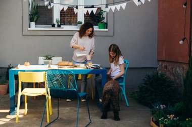 Anne ve kızı birlikte kahvaltı yapıyorlar.