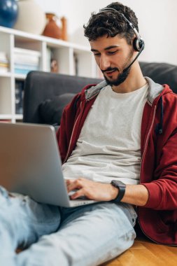 Evde dizüstü bilgisayar kullanan bir adam