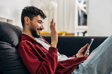 Genç beyaz adam bir video çağrısına cevap veriyor.