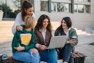 A group of college friends is working on their assignment outside