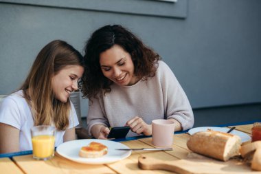 Mother and daughter are having breakfast together