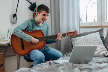 Teenage boy enjoys playing the guitar