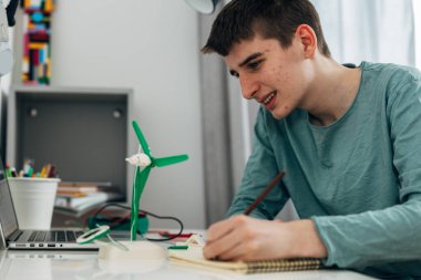 Boy is doing research on a school project about green energy