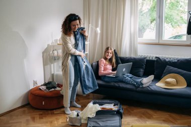 Mother packs suitcase for a trip with her daughter
