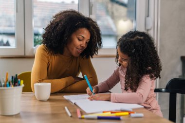 Mother is watching her daughter draw