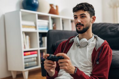 Young man enjoys playing games at home