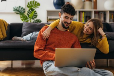 Genç çift evdeki bilgisayara bakıyor.