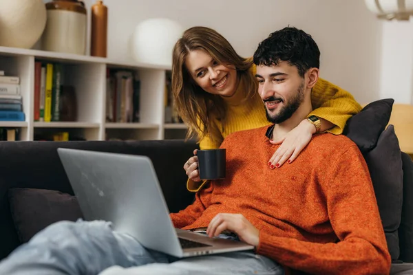 Kadın, erkek arkadaşı evde çalışırken ona kahve ikram ediyor.